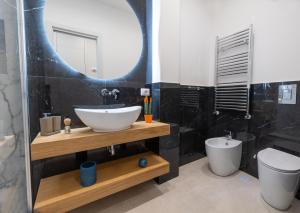 łazienka z umywalką, toaletą i lustrem w obiekcie Napoli City Center - Appartamenti e Camere w mieście Neapol