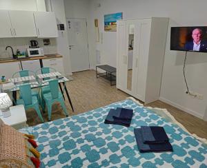 a room with a bed with two towels on it at APARTAMENTOS ELEMAR free luggage storage in Málaga