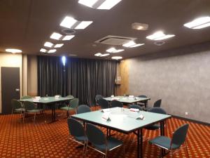 a conference room with tables and chairs and a screen at ibis Douala in Douala