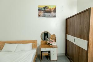 1 dormitorio con cama y mesa con espejo en LING LING'S VILLA en Mộc Châu