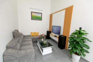 sala de estar con sofá y TV en LING LING'S VILLA en Mộc Châu
