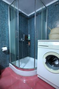eine Waschmaschine im Bad mit Dusche in der Unterkunft Modern 2BD apartment next to Acropolis in Athen