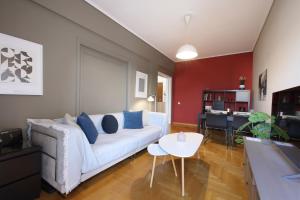 ein Wohnzimmer mit einem weißen Sofa und einem Tisch in der Unterkunft Modern 2BD apartment next to Acropolis in Athen