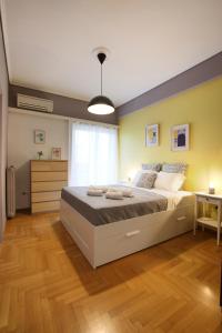 ein Schlafzimmer mit einem großen Bett in einem Zimmer in der Unterkunft Modern 2BD apartment next to Acropolis in Athen