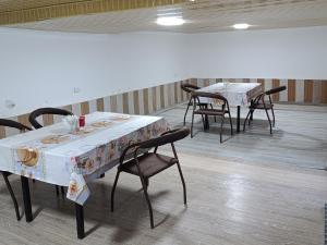 a room with two tables and chairs with white table cloth at Dilnura Guest House in Bukhara