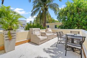 eine Terrasse mit Stühlen und einem Tisch auf dem Balkon in der Unterkunft Villa Venezia BB full house up to 12 guests in Miami Beach