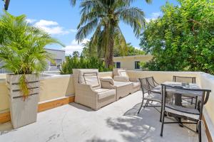 Un patio con sillas y una mesa en el balcón. en Villa Venezia BB full house up to 12 guests en Miami Beach