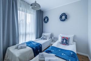 a bedroom with two beds and a window at Flatbook Apartamenty - Jantar Resort in Jantar