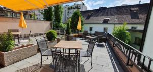 eine Terrasse mit einem Tisch und Stühlen auf dem Balkon in der Unterkunft Hotel Baslertor in Luzern