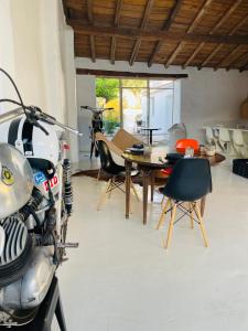motocykl zaparkowany w pokoju ze stołem i krzesłami w obiekcie uma casa em entradas guesthouse w mieście Entradas