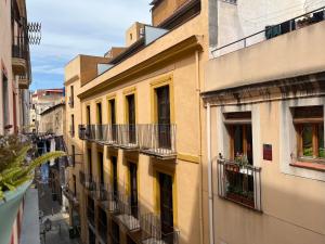 un callejón de edificios con balcones en una ciudad en The Light appartment Tarragona, en Tarragona