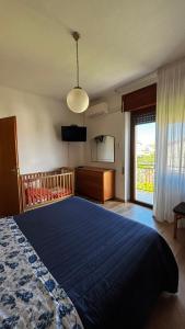 1 dormitorio con 1 cama azul grande y TV en Villetta Lena al Mare, en Vasto