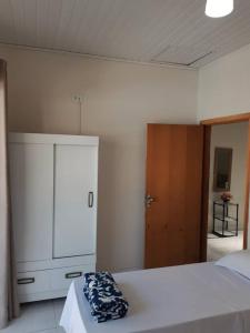 a bedroom with a white bed and a dresser at Casa próximo ao santuário nacional in Aparecida