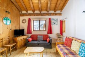 a living room with a couch and a tv at Chalet Les moulins in Bonneval-sur-Arc