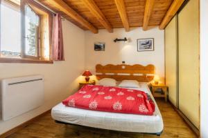 a bedroom with a bed with a red comforter at Chalet Les moulins in Bonneval-sur-Arc