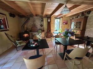 a living room with tables and chairs and a fireplace at Le Clos Pastel in Virac