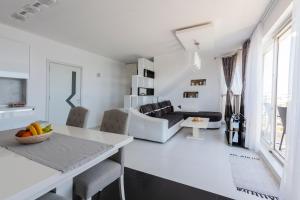 a white living room with a couch and a table at NEA Penthouse in Ahtopol