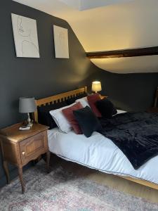 a bedroom with a bed and a table with a lamp at Stunning 2-bedroomed Cottage in Cockermouth