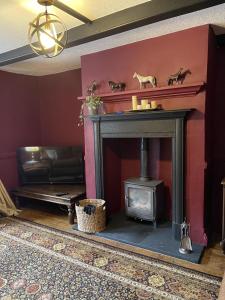 a living room with a fireplace and a couch at Stunning 2-bedroomed Cottage in Cockermouth