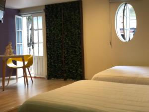 Habitación con 2 camas, mesa y ventana en Hotel Imperial, en Xalapa