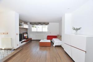 uma sala de estar com paredes brancas e um sofá vermelho em Rey apartment em Vilassar de Mar
