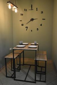 una mesa con dos sillas y un reloj en la pared en Natalia guest house en Kavala
