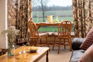 a living room with a table and chairs and a window at The Bothy, Press Mains Farm Cottages in Eyemouth