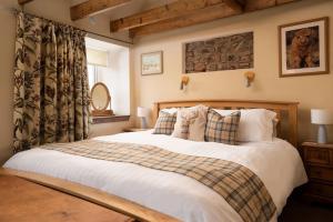 a bedroom with a large bed with white sheets and pillows at The Bothy, Press Mains Farm Cottages in Eyemouth