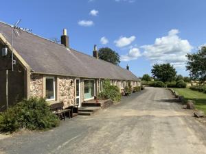 a row of cottages on a dirt road at The Bothy, Press Mains Farm Cottages in Eyemouth
