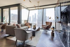 a living room with a couch and chairs and windows at Frank Porter - Burj Vista in Dubai