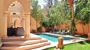 a backyard with a swimming pool and a house at Barthélemy Guest House in Marrakesh