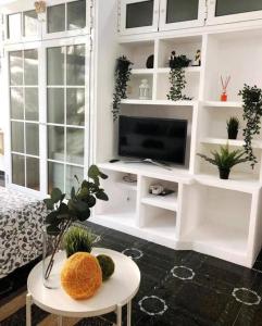 ein Wohnzimmer mit einem TV und einem Tisch in der Unterkunft LM27 Beach by Wave Properties in Las Palmas de Gran Canaria