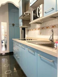 eine Küche mit blauen Schränken und einem Waschbecken in der Unterkunft LM27 Beach by Wave Properties in Las Palmas de Gran Canaria