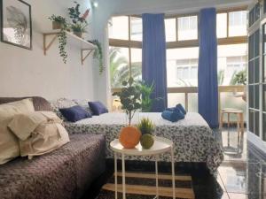 ein Wohnzimmer mit einem Bett, einem Tisch und einem Fenster in der Unterkunft LM27 Beach by Wave Properties in Las Palmas de Gran Canaria