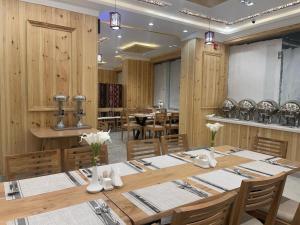 Dvina Hotel في تبوك: غرفة طعام مع طاولة وكراسي طويلة