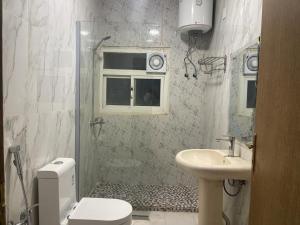 uma casa de banho com um chuveiro, um lavatório e um WC. em Dvina Hotel em Tabuk