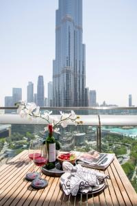 a table with a bottle of wine and glasses on a balcony at Frank Porter - Burj Vista in Dubai