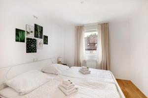 a white bedroom with a bed with two towels at M B Homes in Balzholz