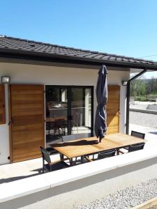 een patio met een houten tafel en een parasol bij Maison climatisée avec piscine privée, 6 personnes in Aiguèze