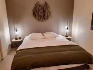 een slaapkamer met een groot bed met 2 lampen bij Maison climatisée avec piscine privée, 6 personnes in Aiguèze