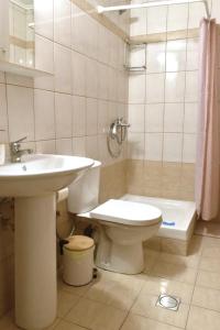 La salle de bains est pourvue de toilettes et d'un lavabo. dans l'établissement Natalia guest house, à Kavala