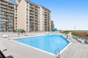 a swimming pool with chairs and a building at Sea Colony Annapolis House II in Bethany Beach