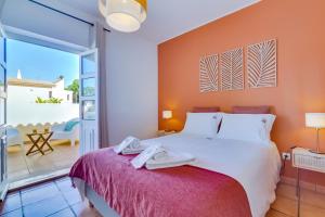 a bedroom with a large bed and a balcony at Villa Oliveiras de Vilamoura by The Portuguese Butler in Quarteira +44 photos