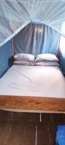 a bed in a tent with two pillows on it at Raja Ampat Blue Sea in Besir