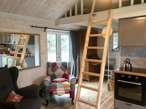 sala de estar con cama elevada y silla en Pippis Cottage en Tingsryd