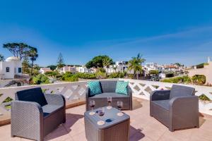 a patio with two chairs and a table with wine glasses at Villa Oliveiras de Vilamoura by The Portuguese Butler in Quarteira