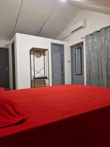 a room with a red bed with a red blanket at Cayenne Centre Payé Eco Confort in Cayenne