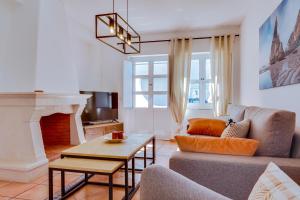 a living room with a couch and a fireplace at Villa Oliveiras de Vilamoura by The Portuguese Butler in Quarteira
