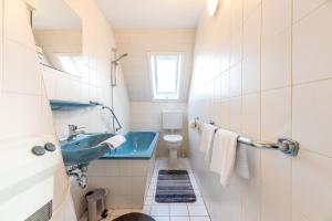 a bathroom with a blue sink and a toilet at Annis Huus NEU in Wyk auf Föhr