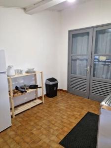 a room with a refrigerator and a wooden floor at Cayenne Centre Payé Eco Confort in Cayenne